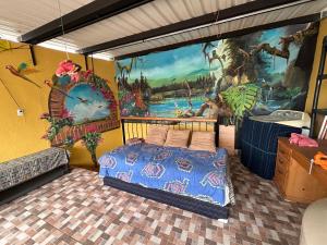 帕纳哈切尔Casa Momo的卧室配有一张床,墙上挂有绘画作品