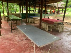 MpigiMpanga Nature Center的一组野餐桌和长凳,位于一个凉亭下