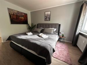 施韦青根Premium Apartments Schwetzingen, Heidelberg, Speyer的一间卧室配有一张大床和两条毛巾