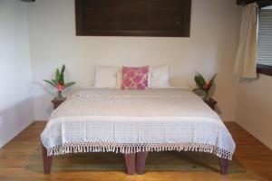 博卡斯德尔托罗Roam Yoga & Wellness Lodge的卧室配有带白色棉被的床
