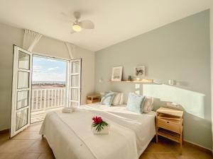 萨尔雷Papaya Apartments Boa Vista的一间卧室,配有一张带鲜花的床