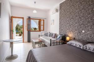 阿莫皮Perama Hotel, Karpathos的酒店客房配有一张床铺和一张桌子。