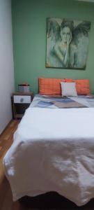 KonakAlsancak Konak seaside 50 mt walk Double room的卧室配有一张壁挂天使照片的床
