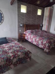 布埃诺布兰当Chalés Recanto das Flores的一间卧室配有两张鲜花床。