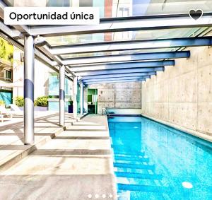 墨西哥城Pollux Luxury apartment的大楼内的一个蓝色海水游泳池