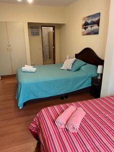 利马Uli´s house的一间卧室配有两张床,上面有粉红色的毛巾