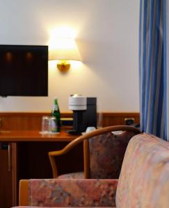 科隆依贝茨嘉利酒店的酒店客房配有一张桌子、一把椅子和一台电视