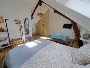 莫雷卢安河L'Echappée Morétaine - Cœur de Moret的一间卧室配有一张大床和一把椅子