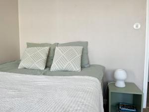 埃斯波Garden city studio的一间卧室配有一张带两个枕头和一张桌子的床。