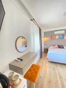 达特恰MAVİ ROTA BUTİK OTEL的一间卧室配有一张床、一张书桌和一面镜子