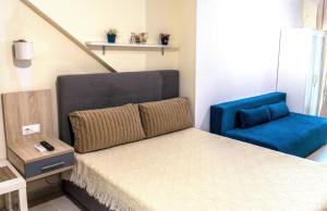 尼亚米卡尼奥纳Roses Apartments的一间卧室配有一张床和一张蓝色椅子