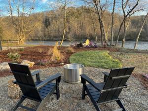 ArdenAsheville River Cabins的两把椅子坐在湖边的砾石庭院