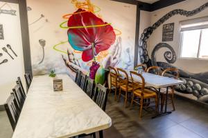 恩塞纳达港Hotel Rose Ensenada的一间带桌子和花壁画的用餐室