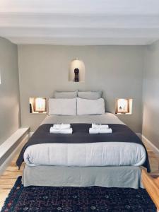 吉维尼Les Grands Jardins Lodge的一间卧室配有一张大床和两条毛巾