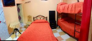 乌尤尼HOTEL ORO BLANCO的一间卧室配有两张双层床,铺有红色床单