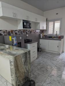 特古西加尔巴Apartamento en Miraflores的一间铺有大理石地板并配有白色橱柜的厨房
