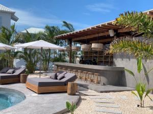 圣佩德罗Casa Serena + The Pool Club @ Mahogany Bay的一个带酒吧和椅子的庭院和一个游泳池
