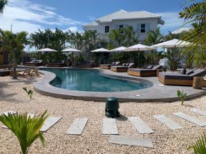 圣佩德罗Casa Serena + The Pool Club @ Mahogany Bay的度假村的游泳池配有躺椅和遮阳伞