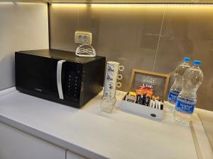 斯科普里Villa Hris I WiFi-Netflix的配有微波炉和瓶装水的柜台。