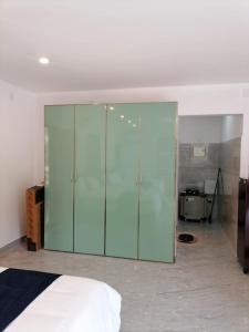 卡萨拉戈德Bekal Village Homestay的卧室内的大型玻璃柜,配有床