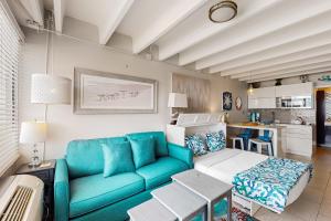 巴拿马城海滩Fontainebleau Terrace 223的一间带蓝色沙发的客厅和一间厨房
