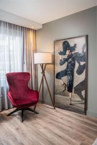 汉堡汉堡机场丽笙酒店的客厅配有红色椅子和绘画