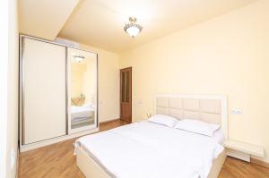 埃里温Amiryan15/7 Excellent apartment in the center的卧室配有一张白色大床和大镜子