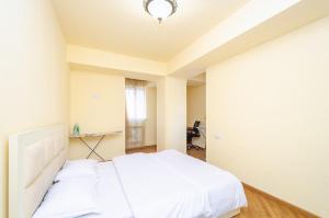 埃里温Amiryan15/7 Excellent apartment in the center的卧室配有白色的床和书桌