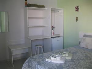 帕拉蒂Pousada Açai的一间卧室配有一张床、一张桌子和书架