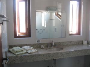 帕拉蒂Pousada Açai的浴室配有盥洗盆、镜子和毛巾