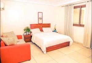 杜阿拉Hannatel Rooms Liberté的一间卧室配有一张床和一张红色的沙发
