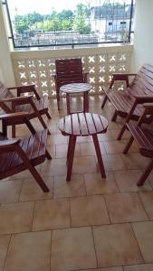 莫罗尼Moifaka Studio Hotel的庭院配有木桌、椅子和桌子