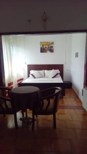 莫罗尼Moifaka Studio Hotel的卧室配有一张床和一张桌子及椅子