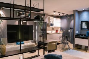 戈亚尼亚Flat Studio DNA Smart style的一间带大电视和厨房的客厅