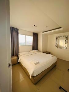 奥隆阿波Chequers Suites Subic Bay的一间卧室设有一张大床和一个窗户。