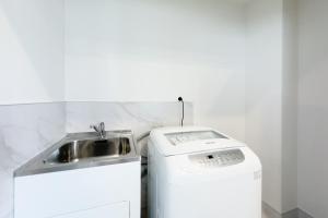 奥克兰Modern 3-bds townhouse in South Auckland的浴室内配有水槽和洗衣机