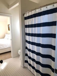 新港Seagrass Cottage at Beverly Beach的浴室设有蓝色和白色的淋浴帘