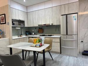 台南Triple One Entire Home 慶東111私人招待所 包棟民宿的厨房配有桌子和冰箱