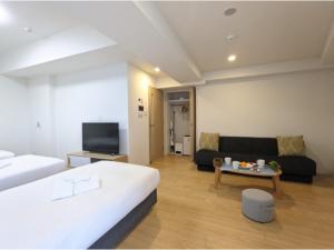 大阪Eslead Hotel Osaka Tsuruhashi - Vacation STAY 77488v的酒店客房,设有两张床和一张沙发