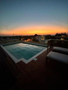 奥尔沃克斯岛Sunsteps casa holbox的一座享有日落美景的建筑屋顶上的游泳池