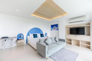 邦萨雷Costa Village Jacuzzi Bangsaray的一间卧室配有一张床、一张沙发和一台电视。