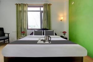 BaghwānpurCapital O Yasmin Resort的一间位于绿色客房内的卧室,配有一张大床