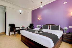 BaghwānpurCapital O Yasmin Resort的一间卧室配有一张大床和紫色墙壁