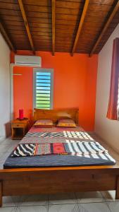 哥西尔Maison (Vu sur le Lagon)的橙色墙壁间的一张床位