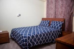 瓦加杜古Kadoued Furnished Apartment 2 Bedroom的卧室配有蓝色被子