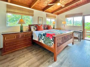凯阿奥Home near Volcano National Park, Hilo, Kehena的卧室配有一张床、一张书桌和窗户。