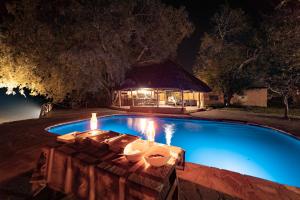 KakumbiNjobvu Safari的游泳池在晚上周围设有蜡烛