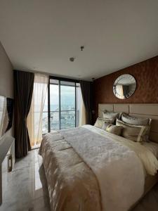 乔木提恩海滩Copacabana Beach Jomtien的一间大卧室,配有一张大床和镜子