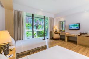 乌鲁瓦图巴厘岛大酒店的配有一张床和一张书桌的酒店客房