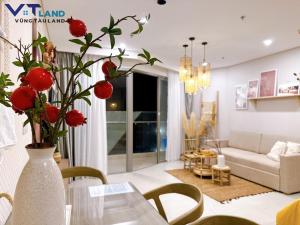 头顿The Sóng Hotel & Apartment Vũng Tàu - VTLand的客厅里装有红色花瓶